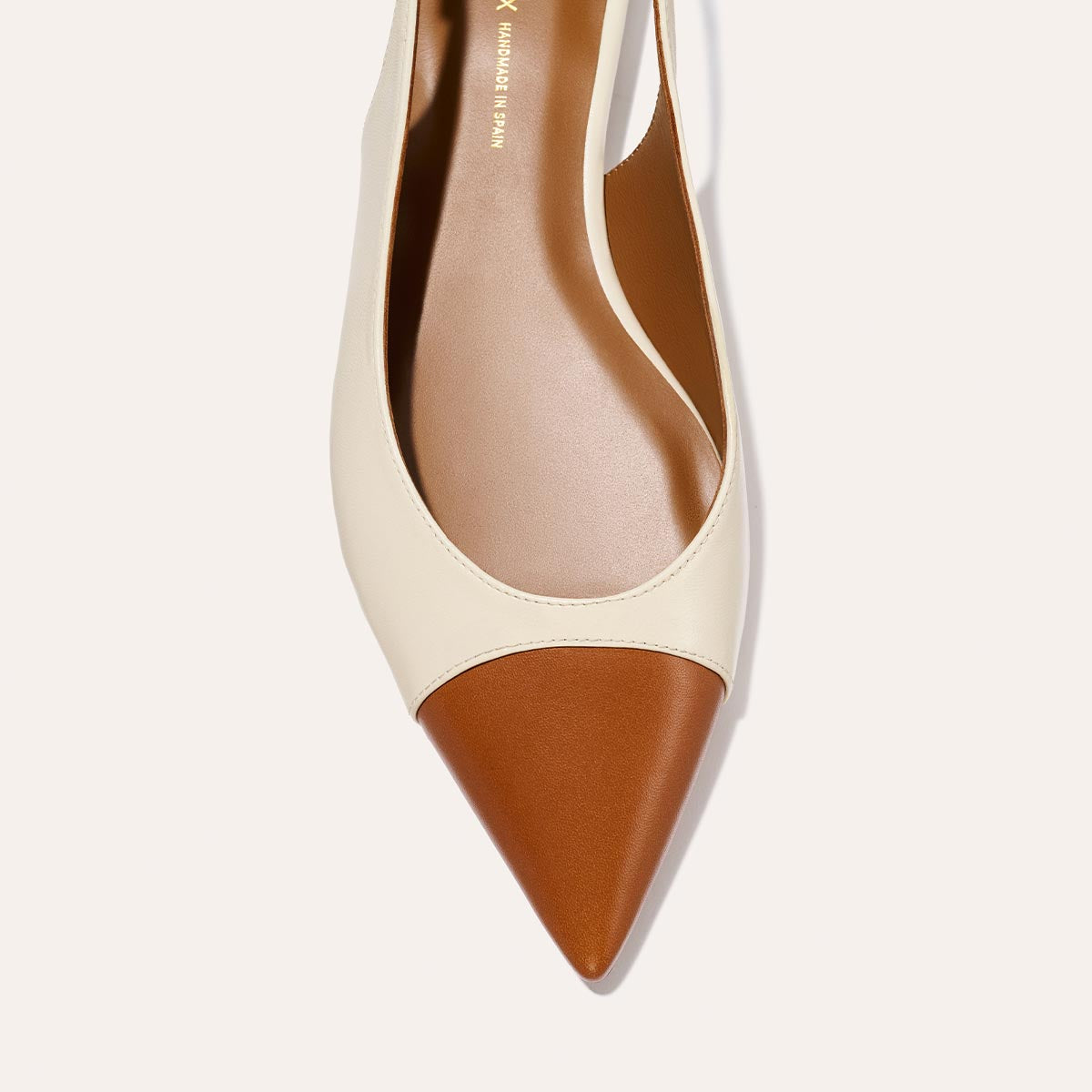 Top view of The Elise by margaux-development, a pointed-toe flat with a tan brown Saddle Nappa tip, cream Cotton upper, sleek minimal design, and brown insole.