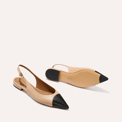 The Elise - Dune and Black Nappa by margaux-development: beige pointed-toe slingback flats with black caps, flat profile, shown on a light background—one upright, one on its side displaying the leather sole.