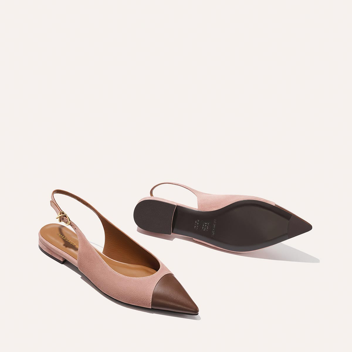 The Elise by margaux-development: women's pointed-toe slingback flats in dusty rose suede and chocolate nappa, with cap toe, gold-buckled ankle straps, low brown heels, and flexible leather soles—one upright, one on its side.