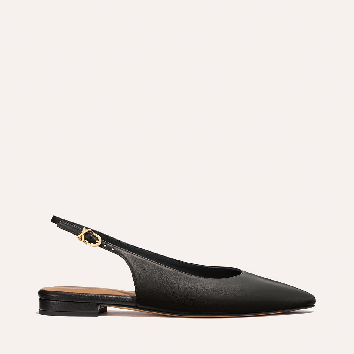 The Elise - Black Nappa by margaux-development is a black leather slingback flat with a pointed toe, low heel, and gold buckle ankle strap, showcased on a plain light background.