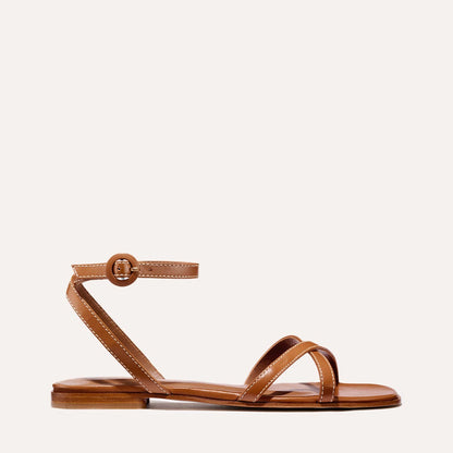 The Flat Sandal in saddle brown nappa, a minimal sandal featuring thin, flattering straps with a subtly square toe.