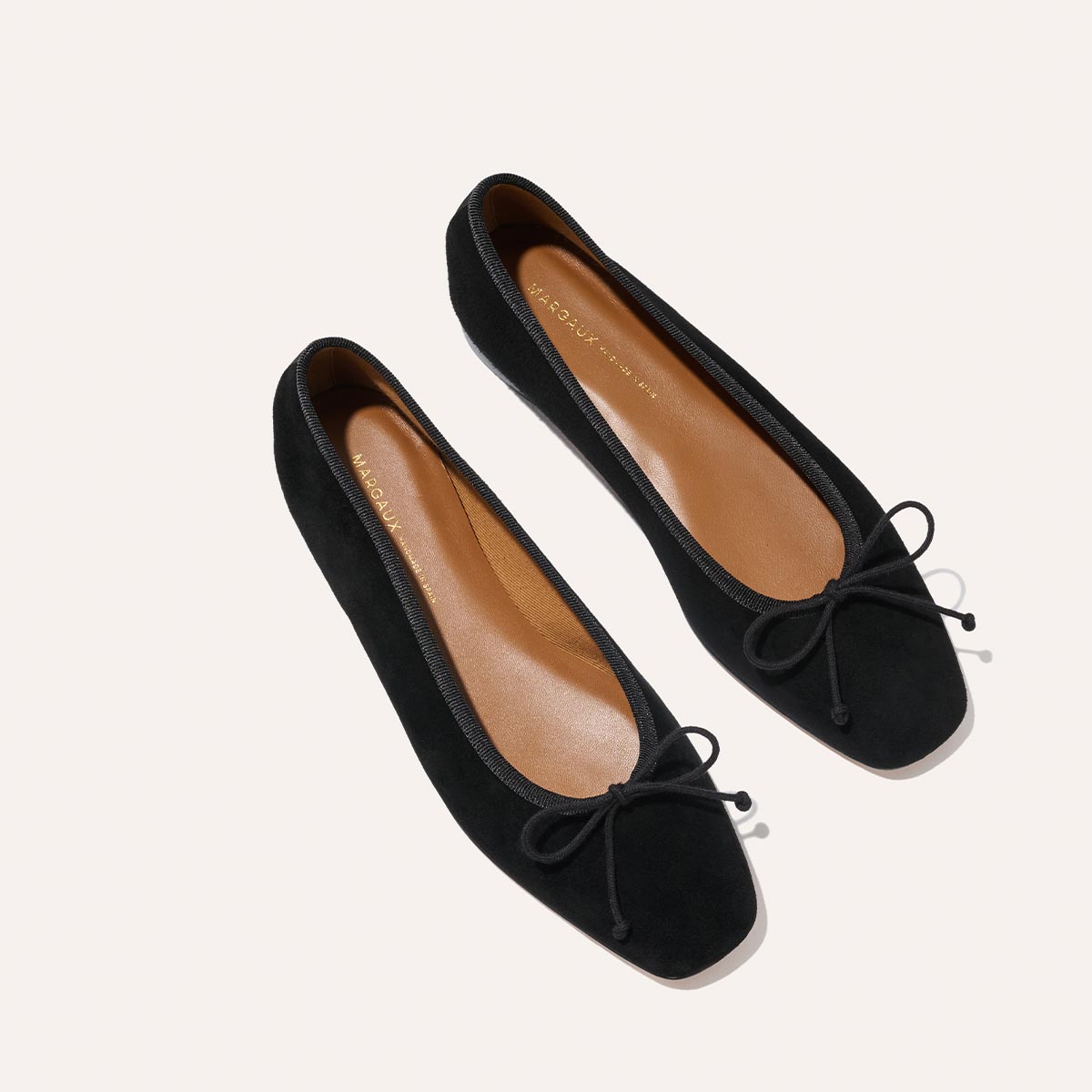 The Fonteyn - Black Suede by Margaux: Handcrafted black suede ballet flats with square toes and elegant black bows, shown on a light background.