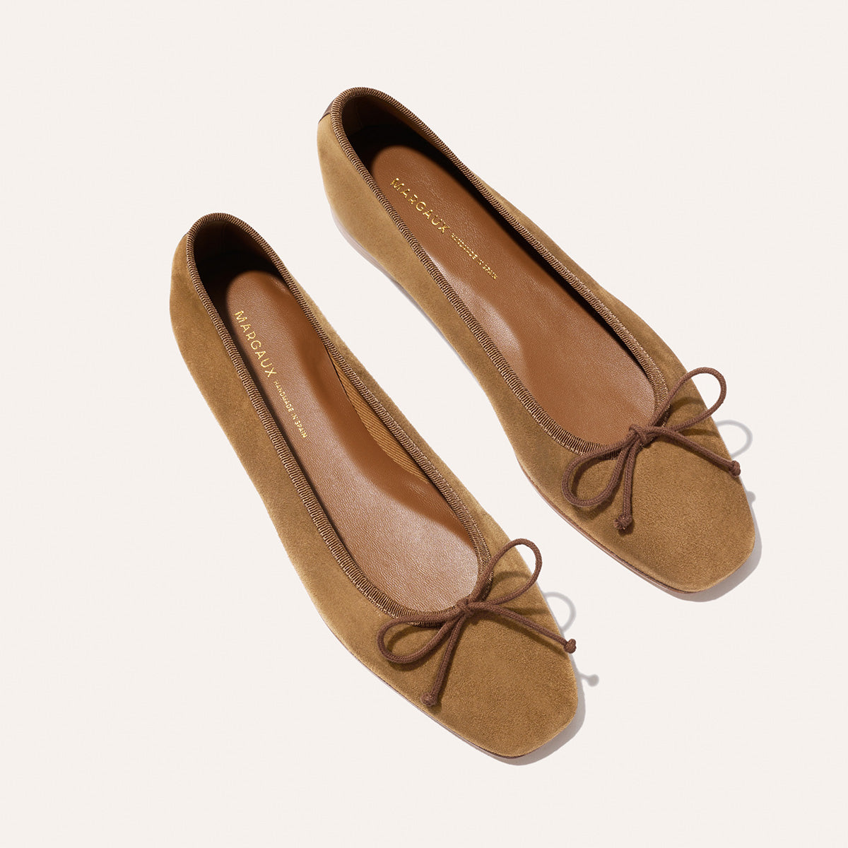 The Fonteyn - Cedar Suede ballet flats in chic tan suede, featuring a square toe and a thin brown bow on the front.
