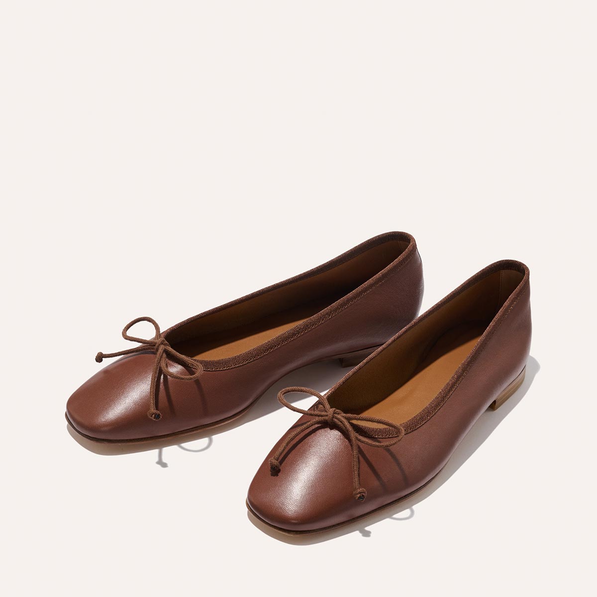 The Fonteyn - Cognac Nappa brown leather ballet flats featuring a chic squared-off toe and a small bow on the front.