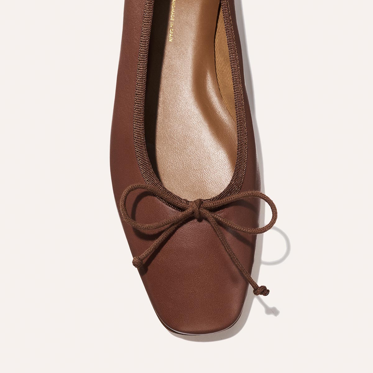 The Fonteyn - Cognac Nappa brown ballet flat with a chic squared-off toe and a delicate bow at the front.