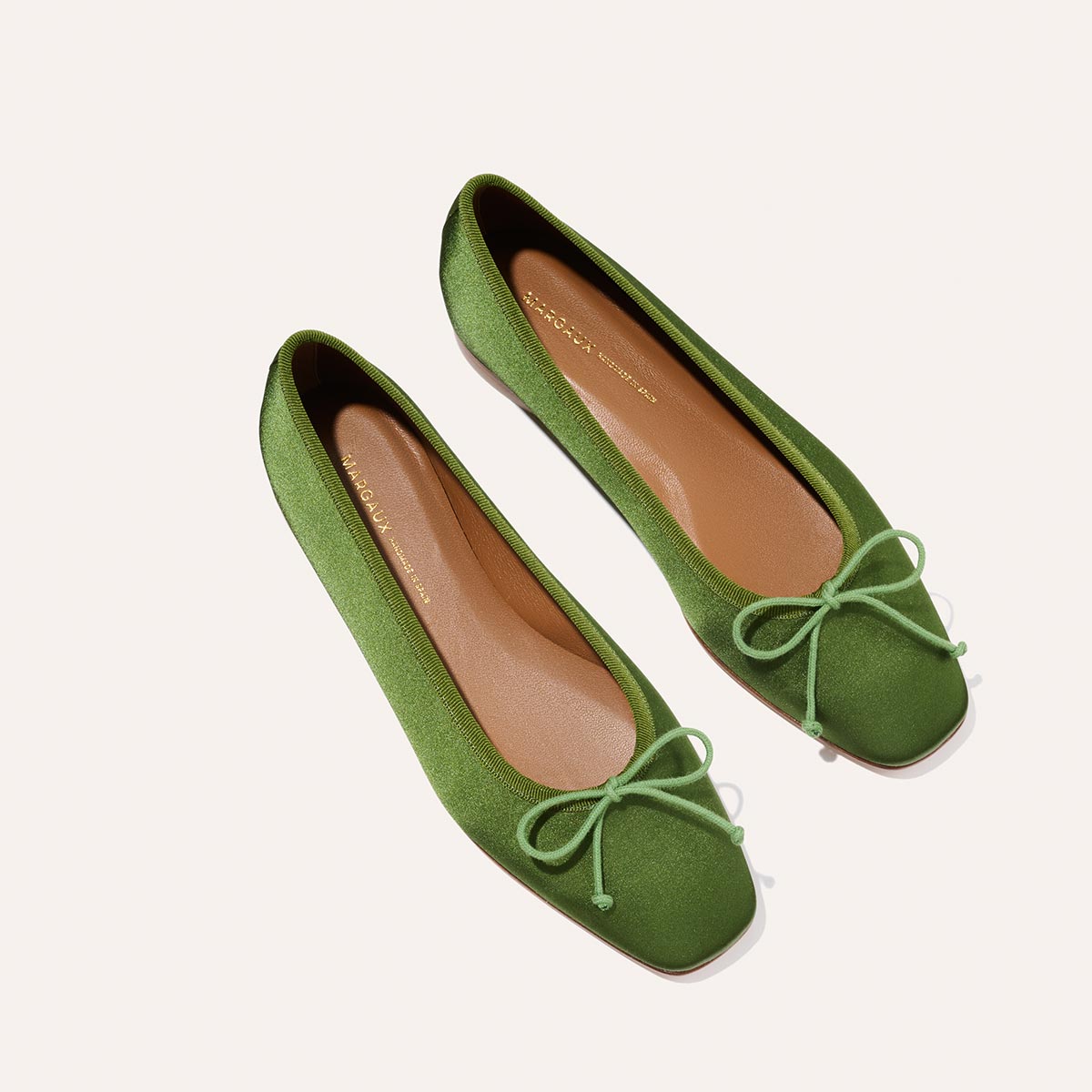 The Fonteyn - Forest Satin by Margaux: handcrafted green ballet flats with square toes and matching bows, displayed on a light background.