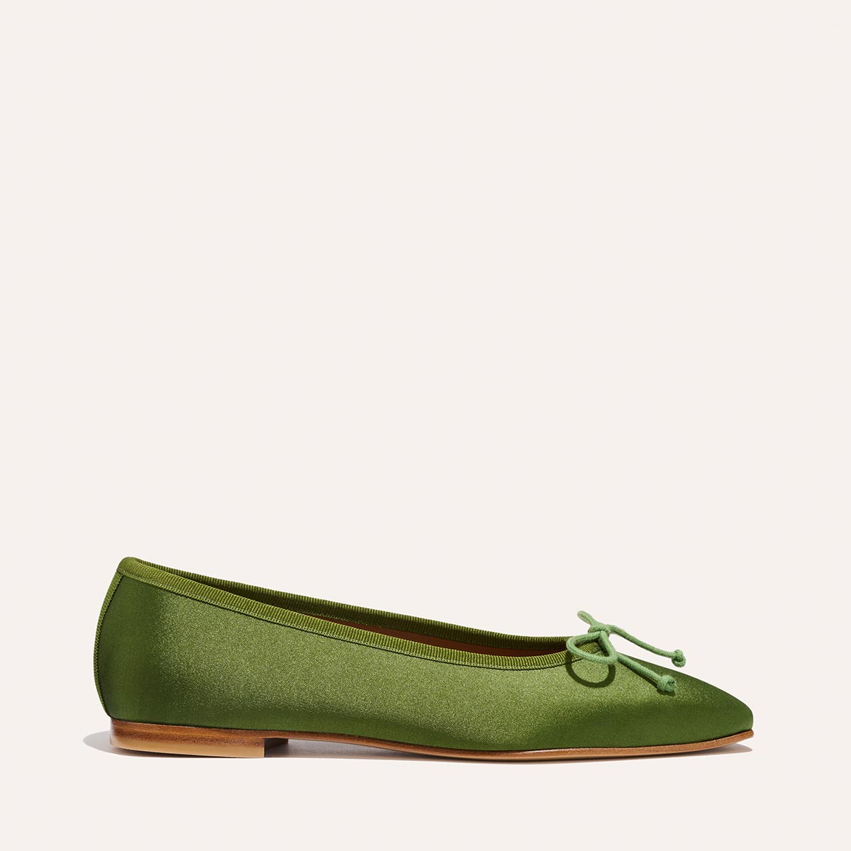 The Fonteyn - Forest Satin by Margaux is a single green ballet flat with a small toe bow and light brown sole, handcrafted for comfort, shown against a plain light background.
