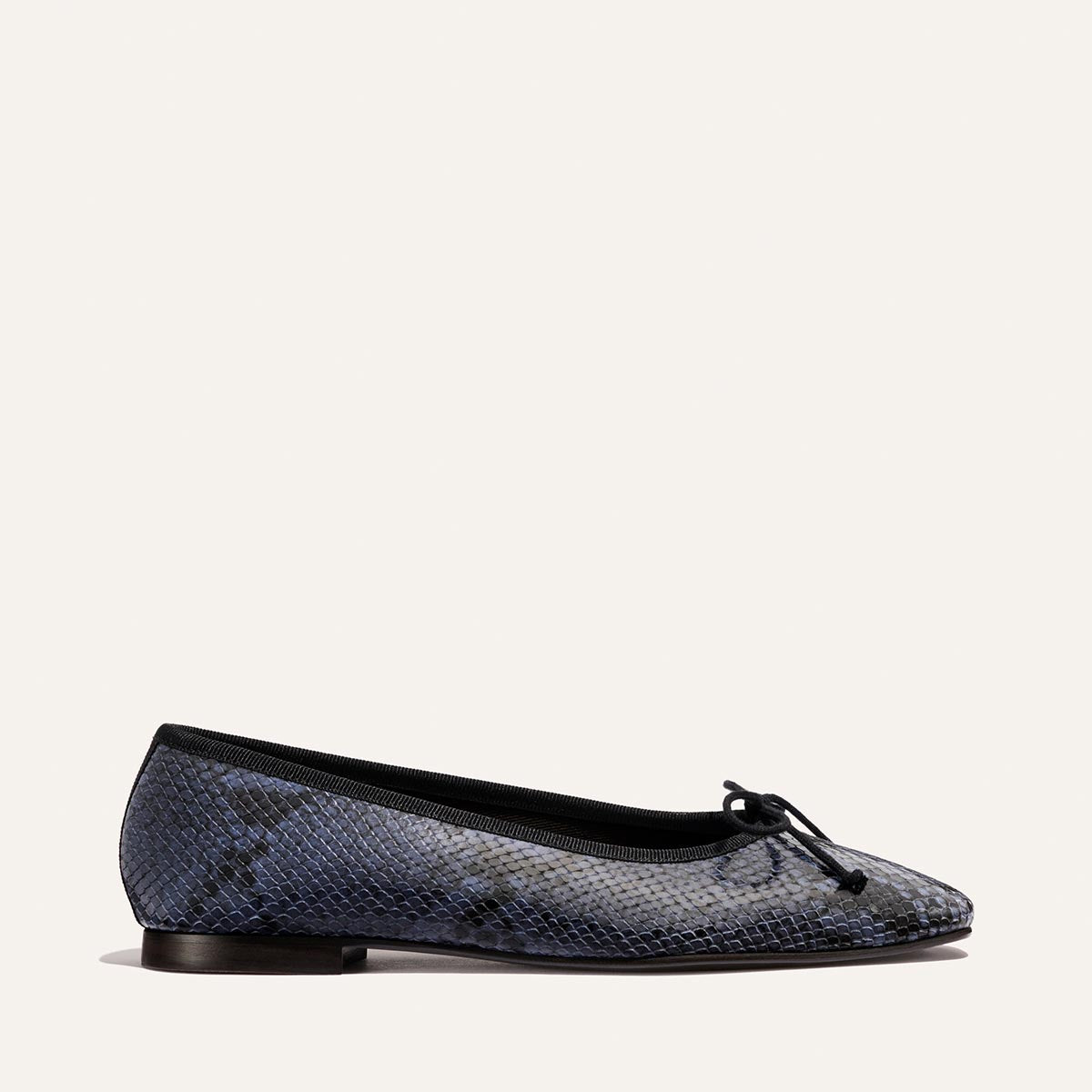 The Fonteyn - Fumo Python Embossed by Margaux: a single blue python-embossed ballet flat with a small black bow, black trim, and flat brown sole, shown on a plain light background.