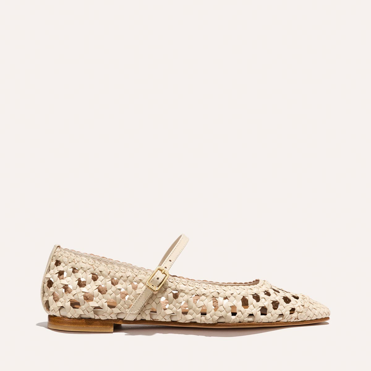 The Fonteyn Jane by Margaux is an ecru woven leather flat featuring a basket-like texture, open weave design, pointed toe, low wooden heel, and adjustable strap.