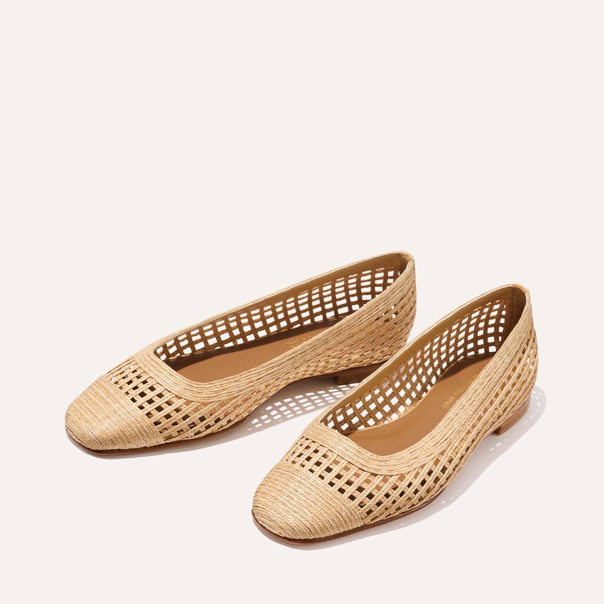 The Fonteyn - Natural Grid Raffia by Margaux features beige woven flats with a grid-like open weave, rounded toes, and a low heel—perfect for adding playful style to your look.