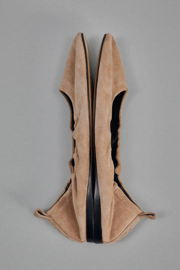 Pair of tan high-heeled shoes on a gray background