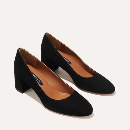 The Heel in Black Suede, a classic block heel featuring a sleek almond toe design complemented by a comfortable 2.5-inch heel.