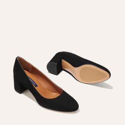 The Heel in Black Suede, a classic block heel featuring a sleek almond toe design complemented by a comfortable 2.5-inch heel.