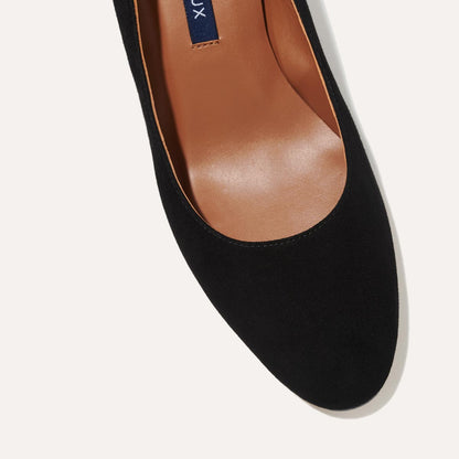 The Heel in Black Suede, a classic block heel featuring a sleek almond toe design complemented by a comfortable 2.5-inch heel.