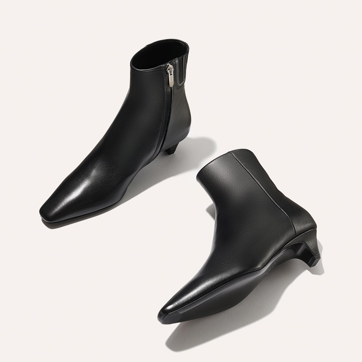 The Alex Mill x Margaux: The Inga - Black Calf from margaux-development are sleek black kitten heel boots with a side zipper and short heels, ideal for chic city strolls.