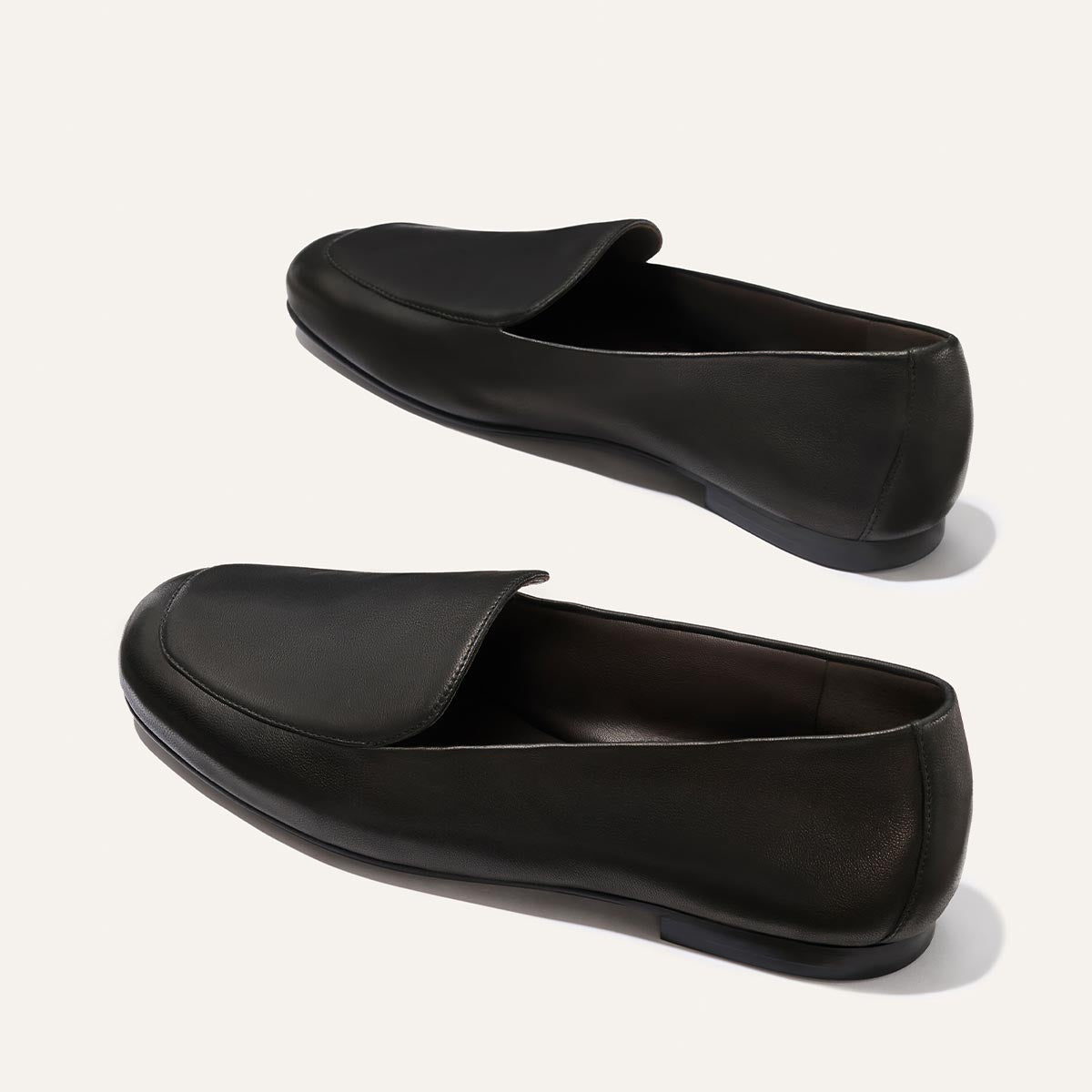 The James Loafer by Margaux in Black Nappa features rounded toes and low heels, crafted from leather. Shown on a plain light background.