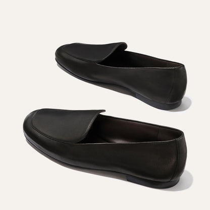 The James Loafer by Margaux in Black Nappa features rounded toes and low heels, crafted from leather. Shown on a plain light background.