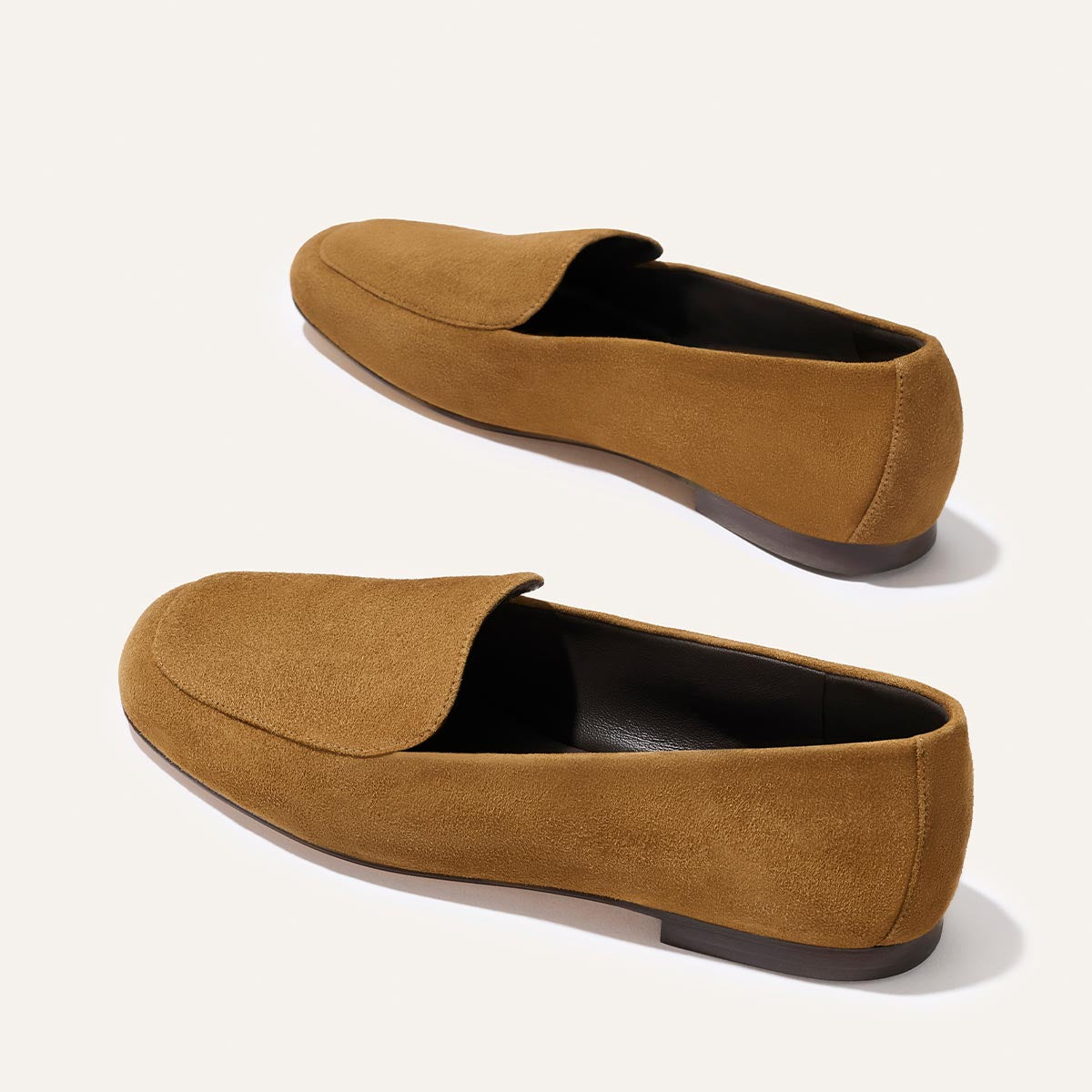 The James Loafer - Cedar Suede by Margaux: minimalist, slip-on brown suede loafers with rounded toes and low dark soles, shown on a light background.