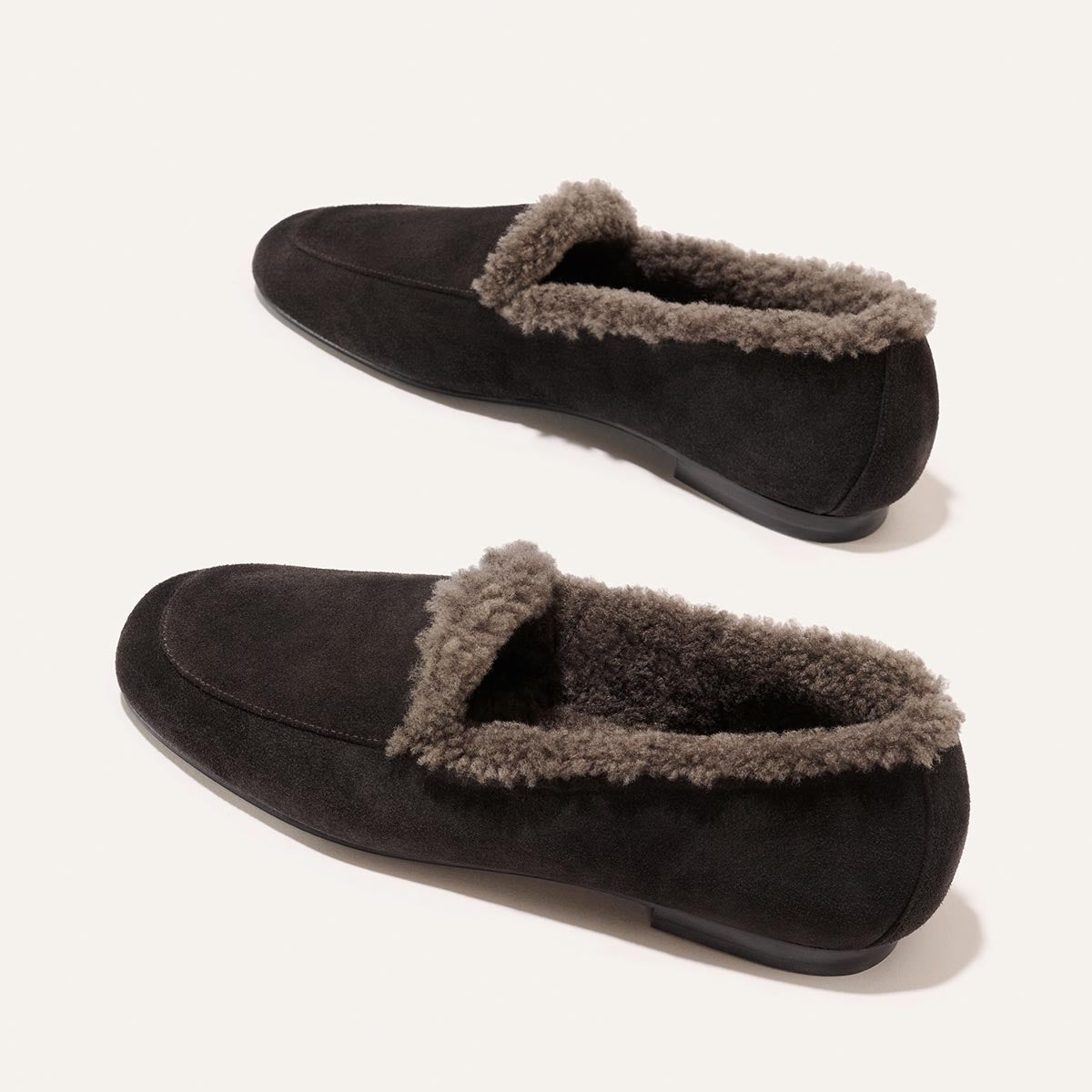A pair of handmade The James Loafer - Dark Chocolate Suede and Shearling dark brown suede loafers lined with grey shearling.
