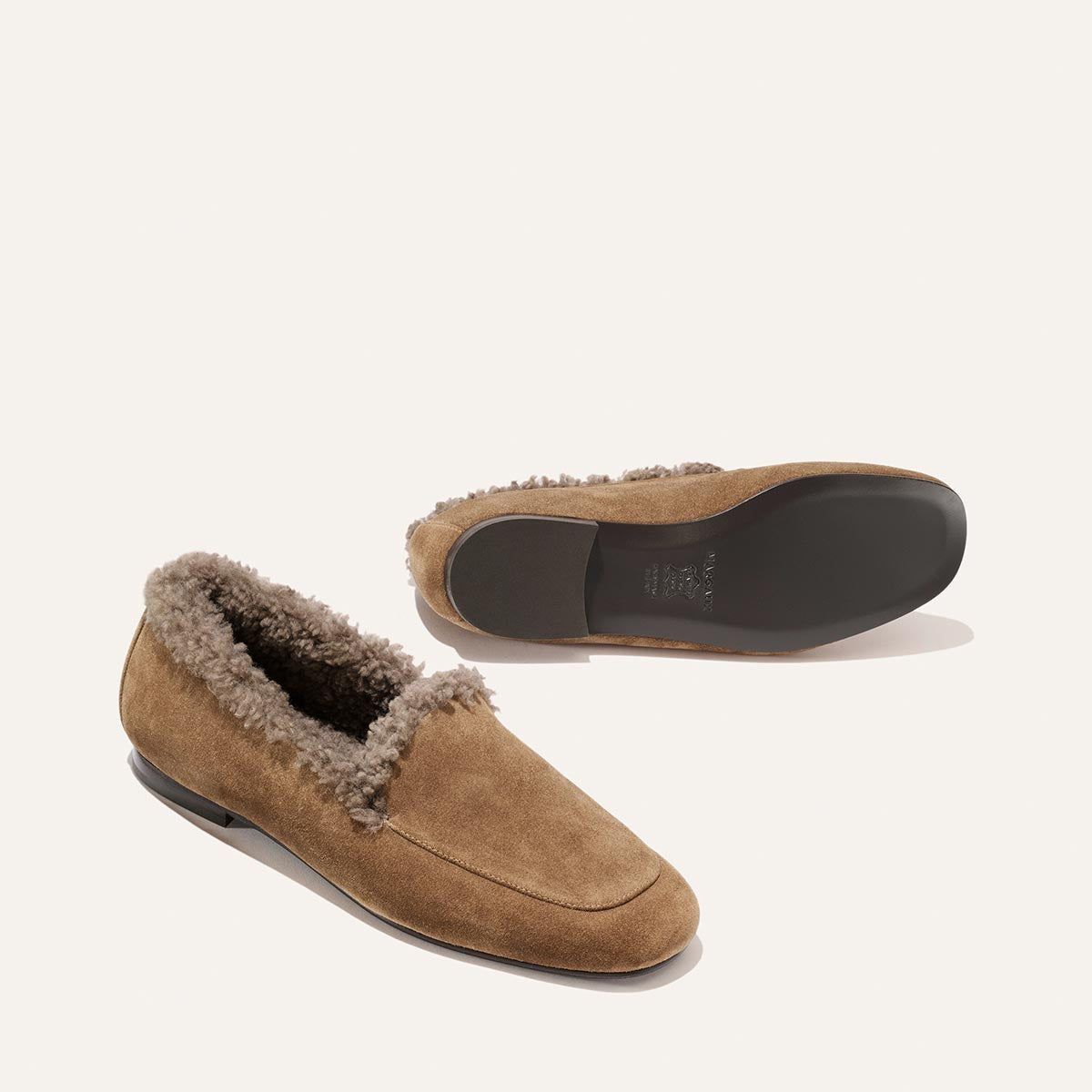 Two The James Loafer - Driftwood Suede and Shearling shoes, one viewed from above and one showing the sole, crafted with sacchetto construction.