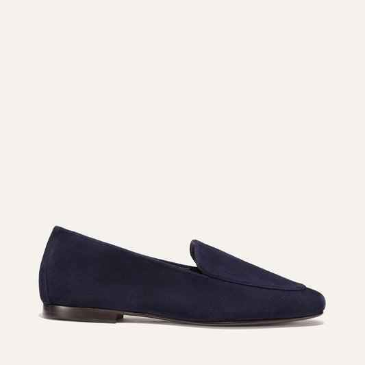 Introducing The James Loafer in Indigo Suede by Margaux—a handmade loafer crafted from rich navy blue suede, featuring a low wooden heel and a tailored fit. Photographed from the side against a plain white background.