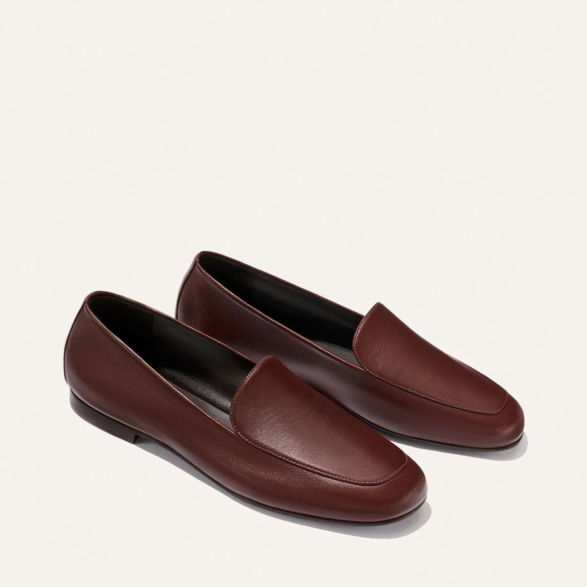 The James Loafer - Mahogany Nappa by Margaux is a pair of brown leather sacchetto loafers with a simple, classic design, displayed on a light background—expertly crafted for slipper-level comfort.