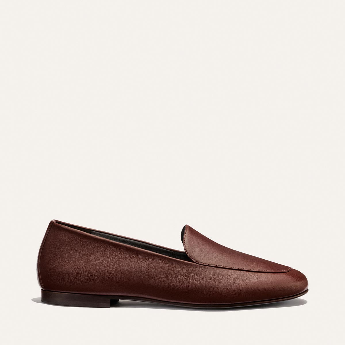 The James Loafer - Mahogany Nappa by Margaux, a brown leather loafer featuring a rounded toe and low heel, celebrated for its slipper-like comfort, is shown in profile against a plain white background.