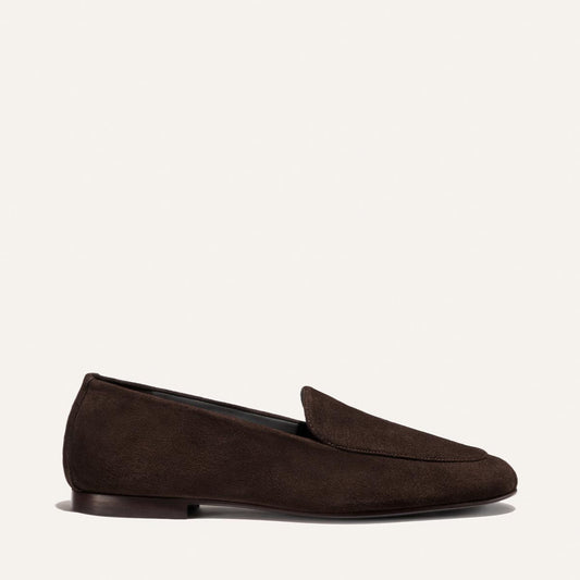 The James Loafer - Molasses Suede by Margaux is displayed in profile against a plain light background, featuring rich dark brown suede, a low heel, elegant sacchetto construction, and a tailored fit.