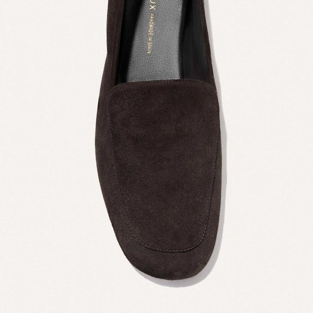 A close-up top view of The James Loafer in Molasses Suede by Margaux on a light background, highlighting its rounded toe, smooth suede finish, and signature slipper-like comfort.