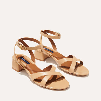 The Lena Sandal in Dune Nappa, featuring perfectly placed straps around the ankle and toes and a comfortable 1.5-inch block heel.