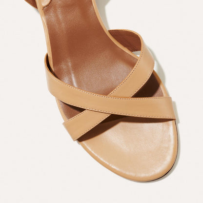 The Lena Sandal in Dune Nappa, featuring perfectly placed straps around the ankle and toes and a comfortable 1.5-inch block heel.