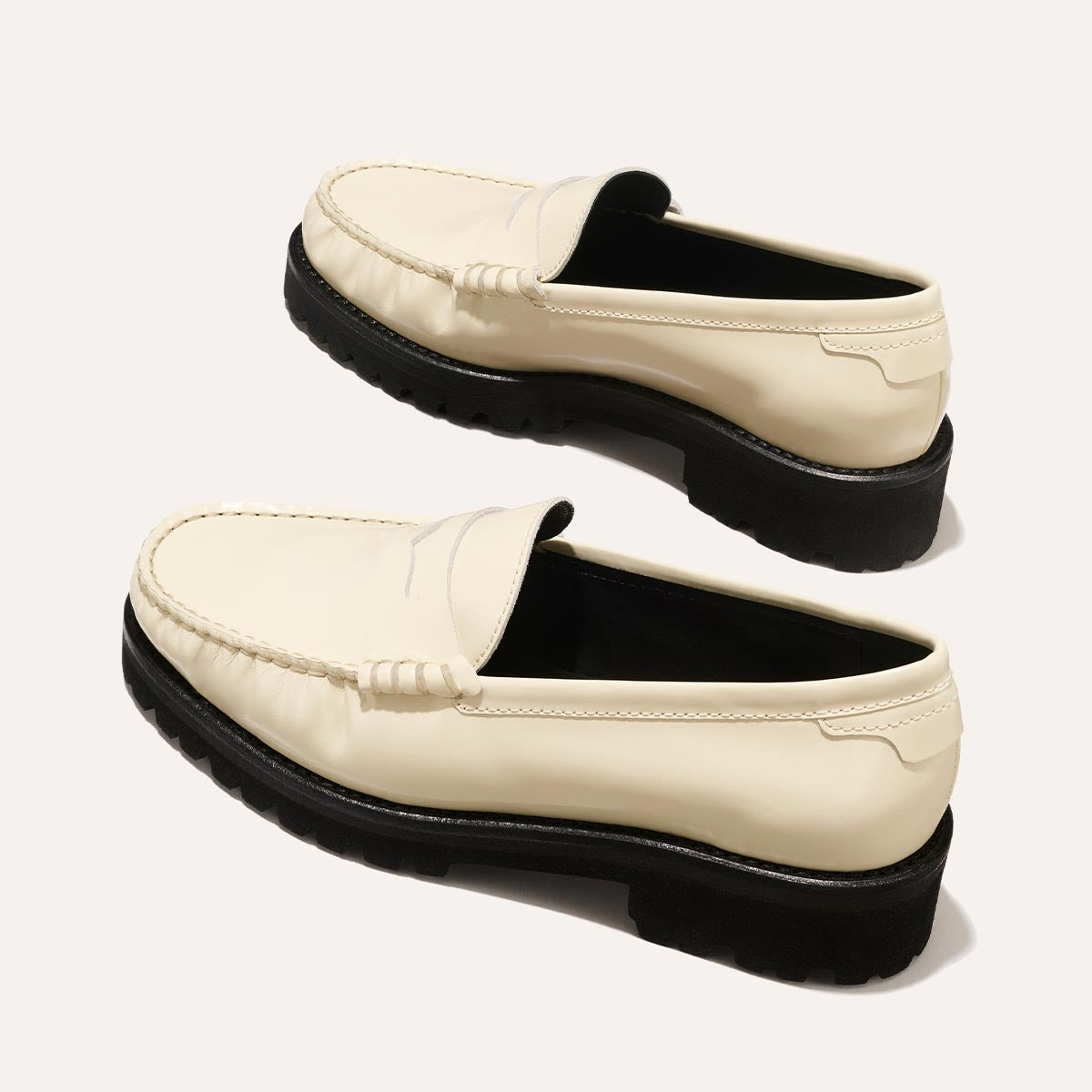 The Louisa Loafer in Cream Calf, a leather penny loafer with chunky lug sole, featuring high-shine abrasivato leather and a lightweight design.