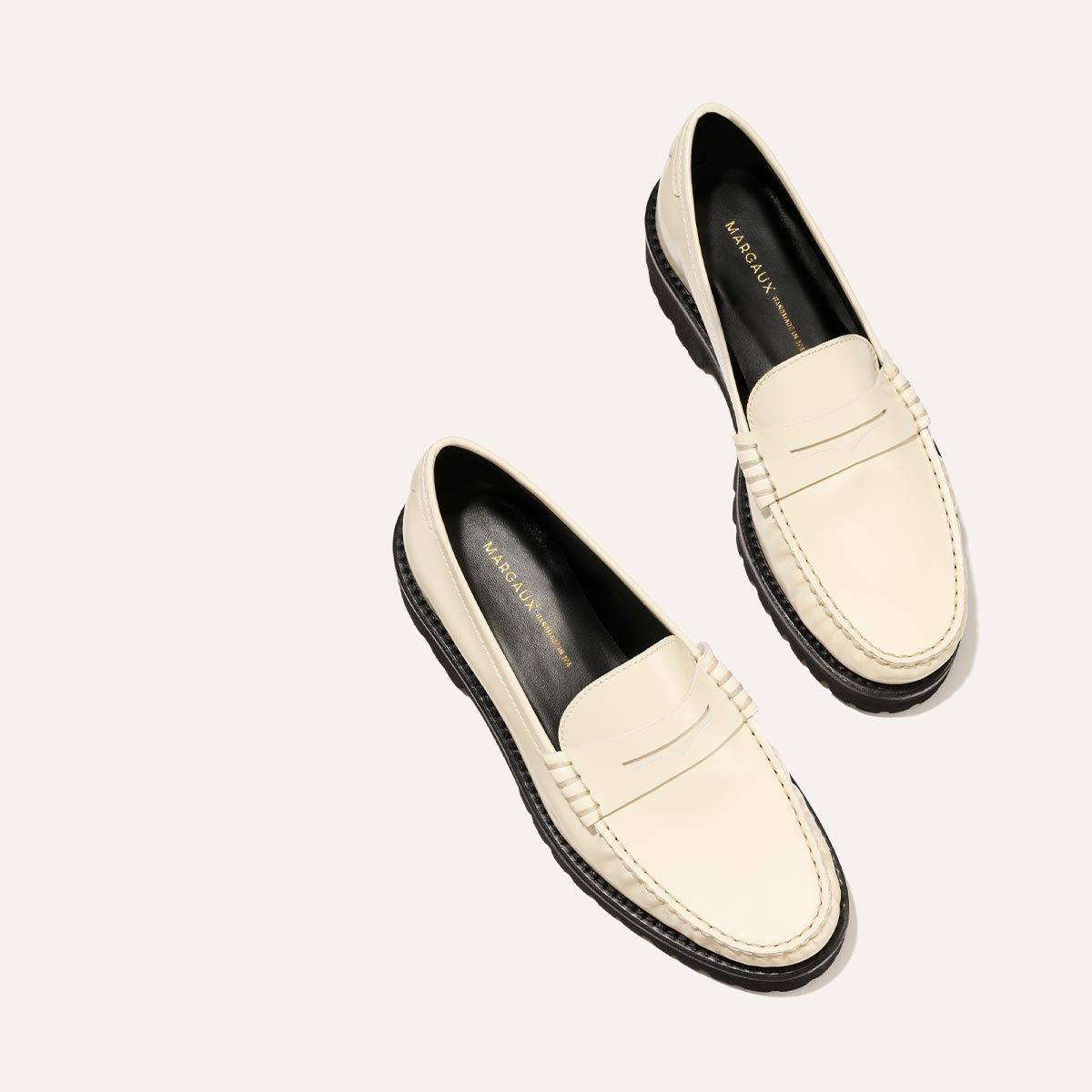 The Louisa Loafer in Cream Calf, a leather penny loafer with chunky lug sole, featuring high-shine abrasivato leather and a lightweight design.