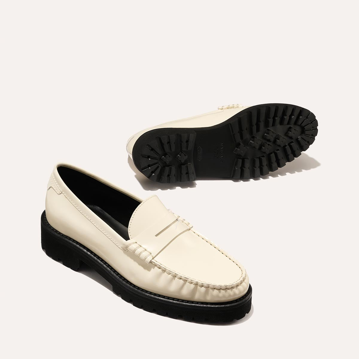 The Louisa Loafer in Cream Calf, a leather penny loafer with chunky lug sole, featuring high-shine abrasivato leather and a lightweight design.