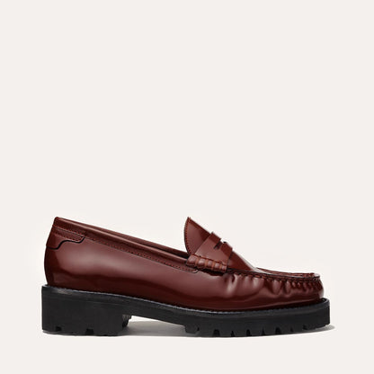 The Margaux Louisa Loafer First Edition in hickory calf is shown in profile with a chunky black lug sole, leather lining, and a light background—bringing bold elegance to any outfit.