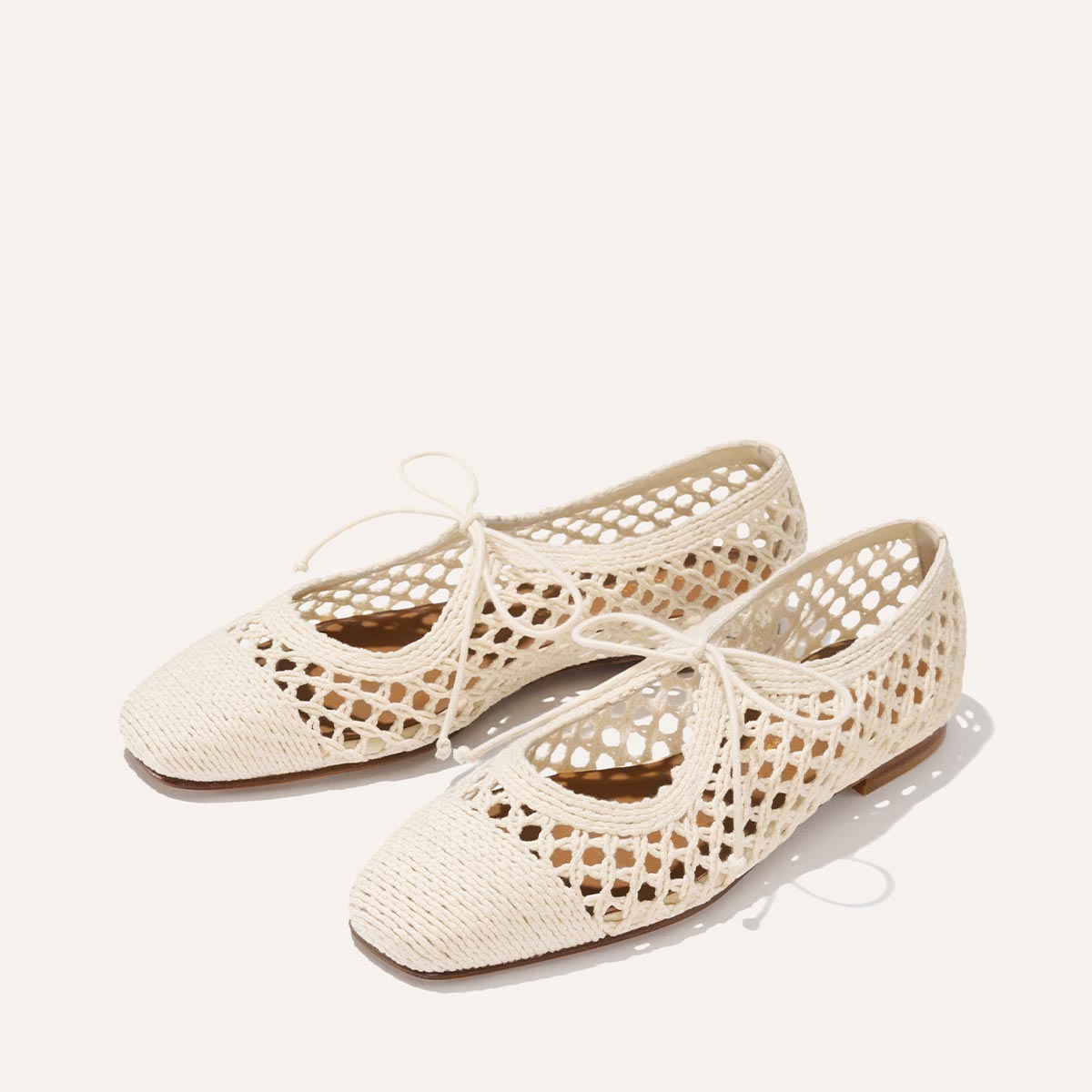 The Luna - Ecru Macrame ballet flats by Margaux feature a beige cotton mesh design and delicate bow-tied laces, offering an effortless summer style, shown on a light background.
