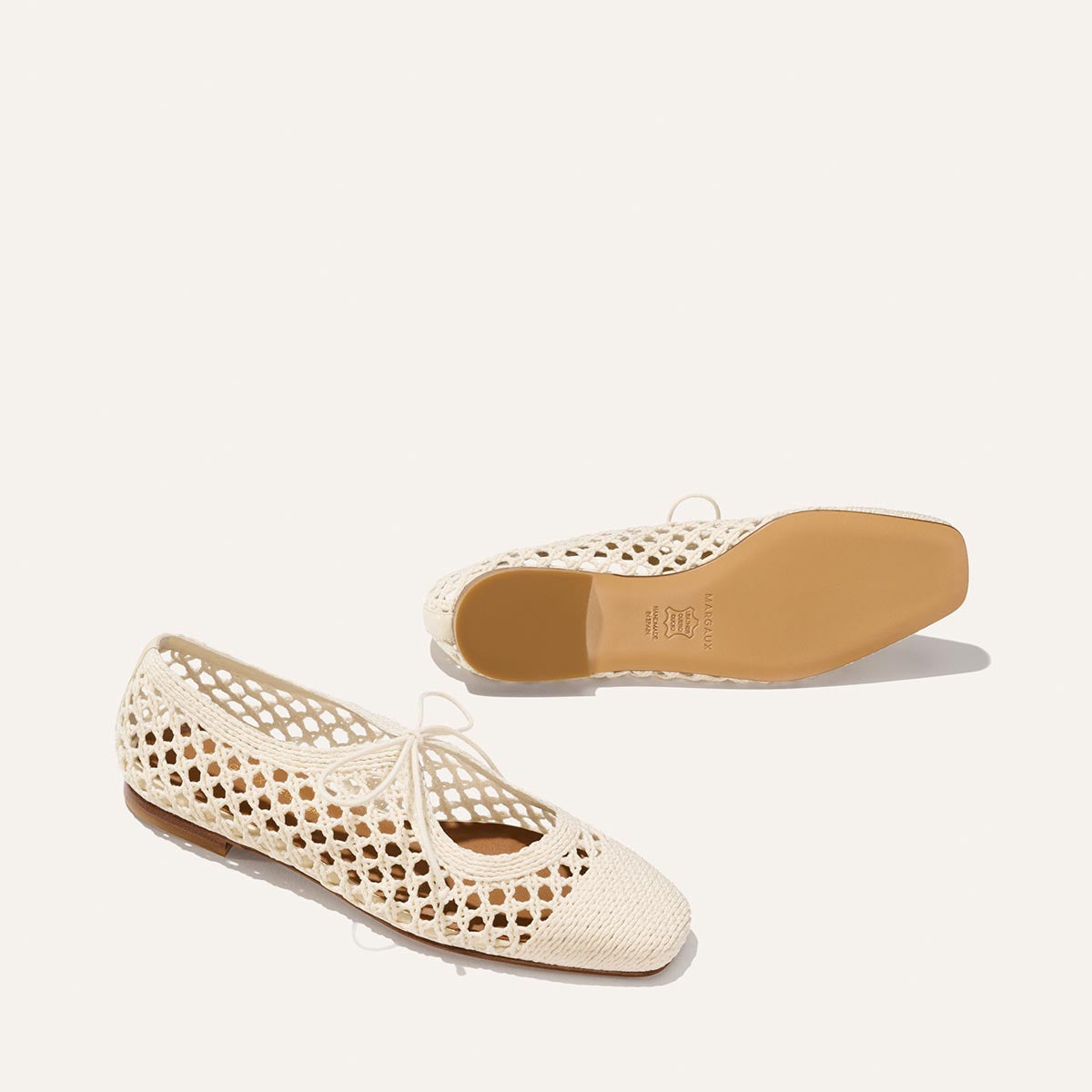 The Luna - Ecru Macrame by Margaux: cream cotton ballet flats with mesh design and tan soles, shown flat and on its side against a light background—ideal summer shoes.