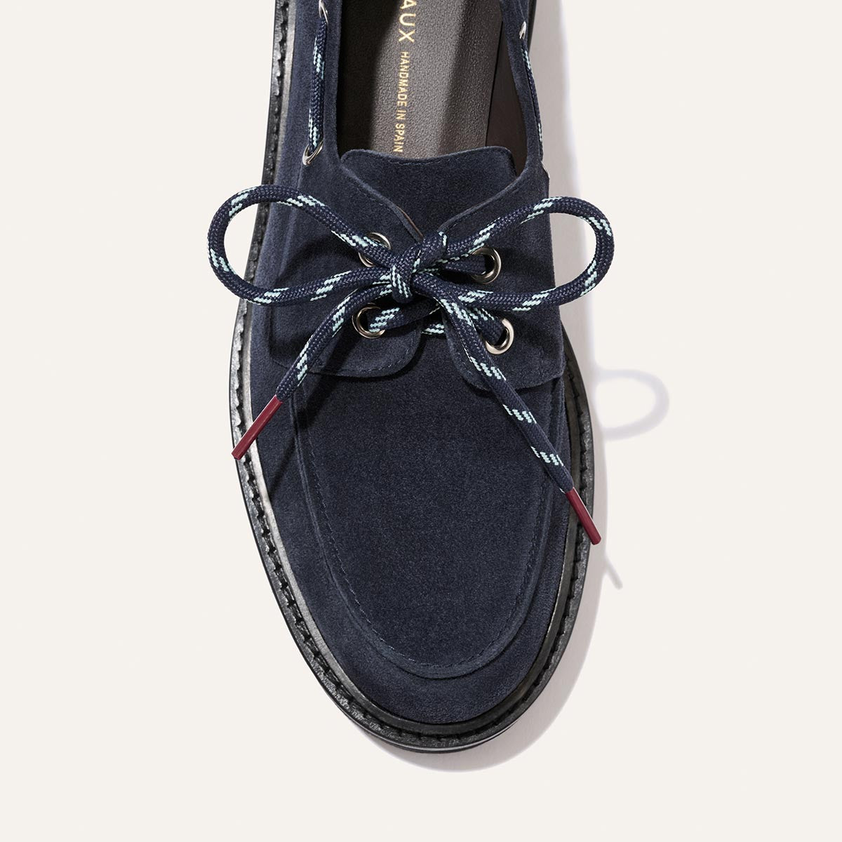 Top-down view of The Marine Loafer - Vintage Navy Suede boat-shoe loafer with patterned laces tied in a bow and a lightweight lug sole.