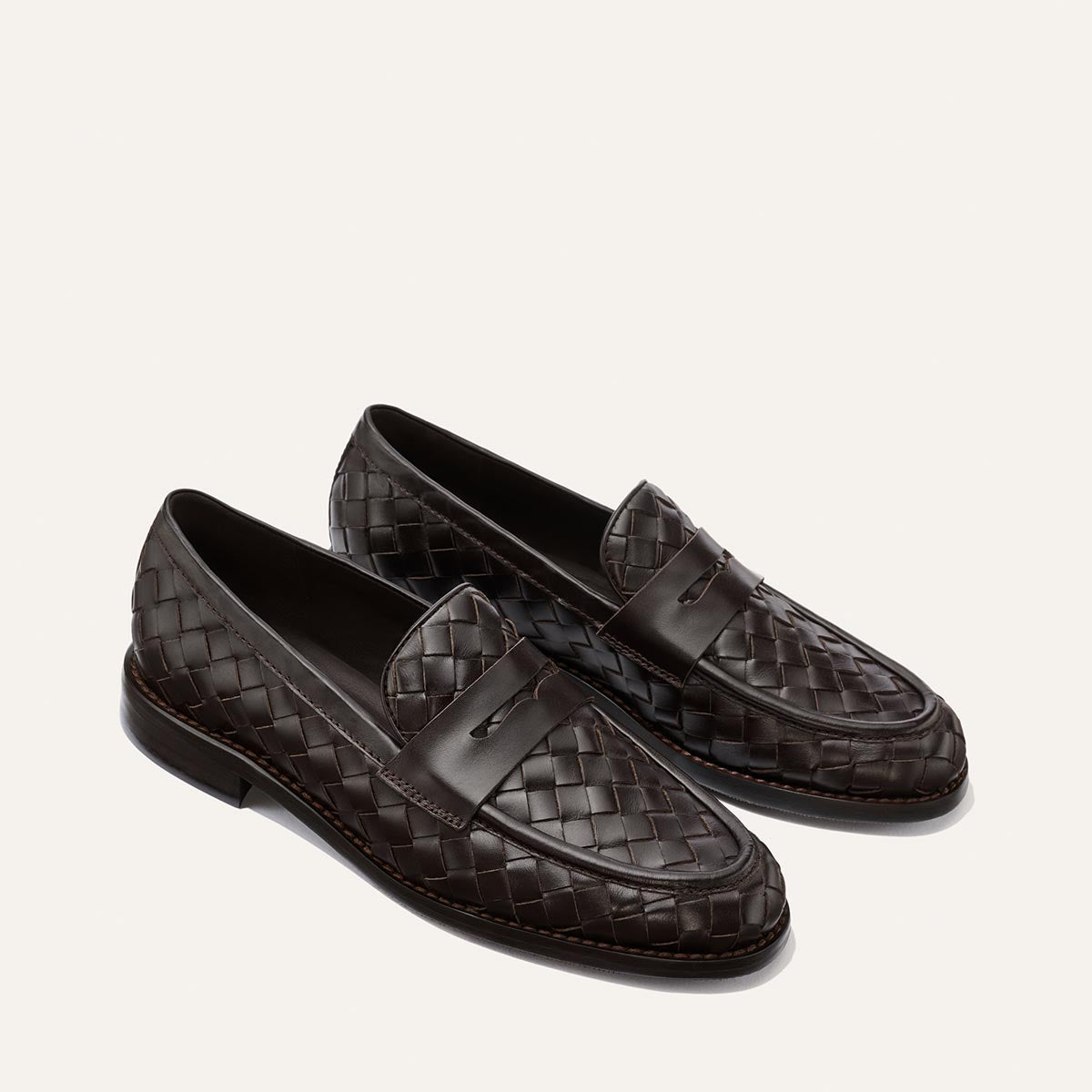 The Marlowe Loafer by Margaux, crafted from brown woven Pasado calf, features a sleek penny strap and timeless design—an effortless closet staple for refined style, shown here on a plain light background.