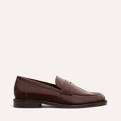 The Marlowe Loafer - Mahogany Calf by Margaux is shown in profile, featuring brown leather, stitched detailing, and a low heel against a plain light background.