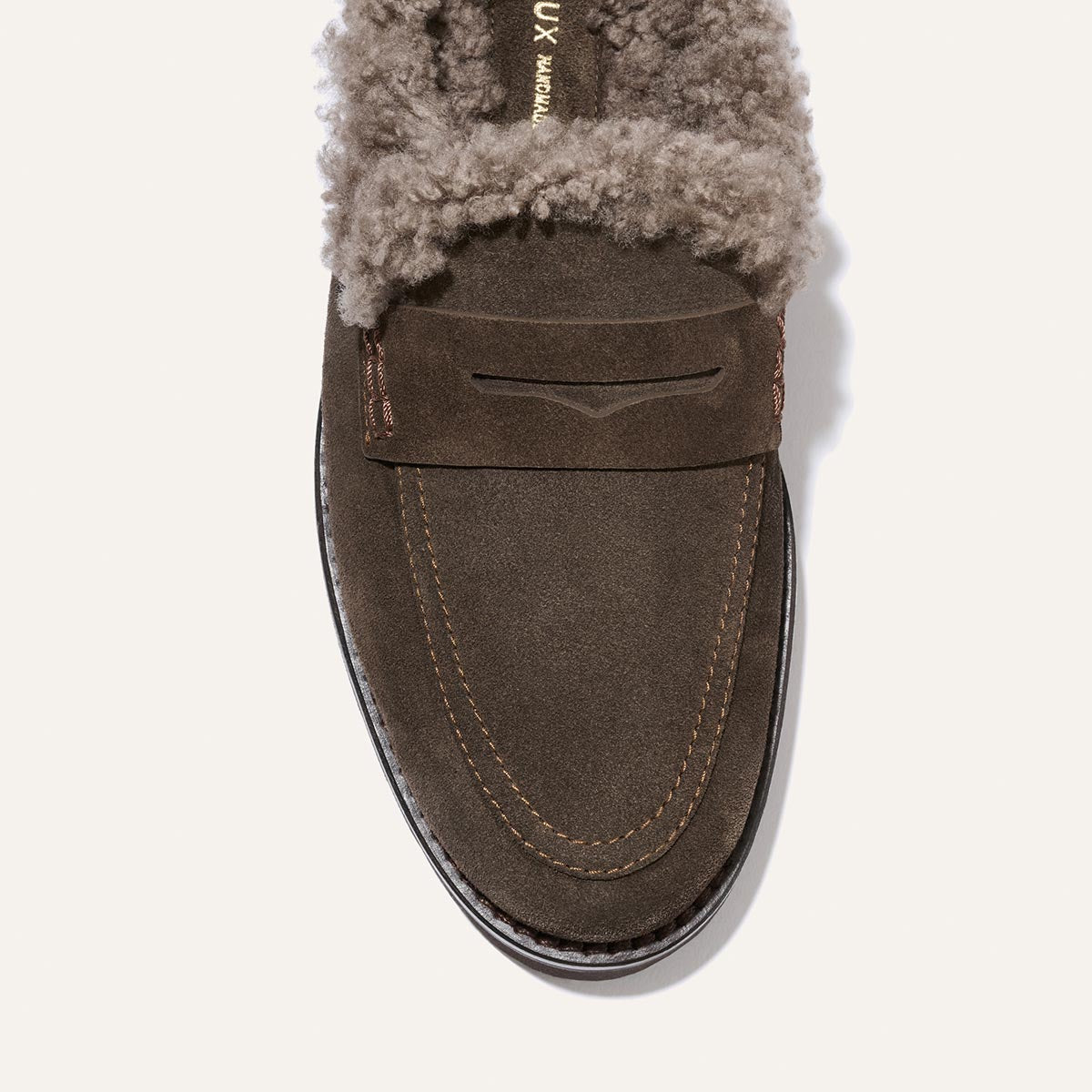 Top view of Margaux’s The Marlowe Mule in English Brown suede, featuring brown stitching and a plush, light brown shearling lining inside.