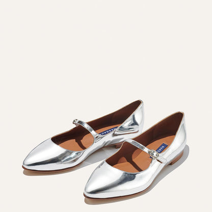 The Mary Jane in shiny Silver Mirror Patent, a ballet flat with a pointed toe and an adjustable strap for a secure fit.