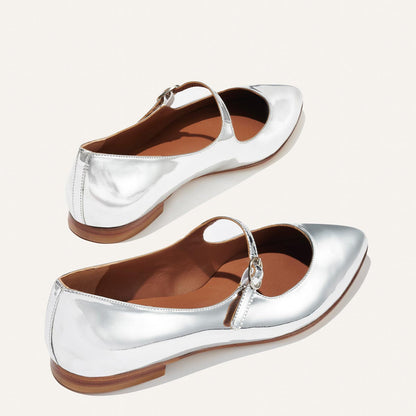 The Mary Jane in shiny Silver Mirror Patent, a ballet flat with a pointed toe and an adjustable strap for a secure fit.