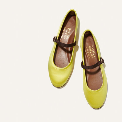 A pair of The Demi Jane - Citron Satin flats by Margaux, featuring yellow satin with brown straps and rounded toes, is displayed on a white background. The insoles are labeled MATILDA Cordera.