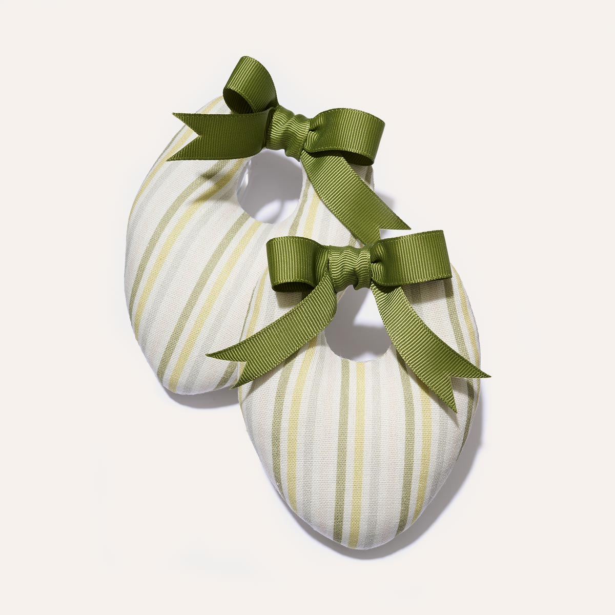 Two Canvas Shoe Shapers from the Matilda Goad x Margaux collection by Margaux, featuring green and white stripes and topped with large green bows, are displayed on a plain light background.