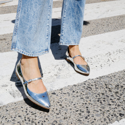 The Mary Jane in shiny Silver Mirror Patent, a ballet flat with a pointed toe and an adjustable strap for a secure fit.