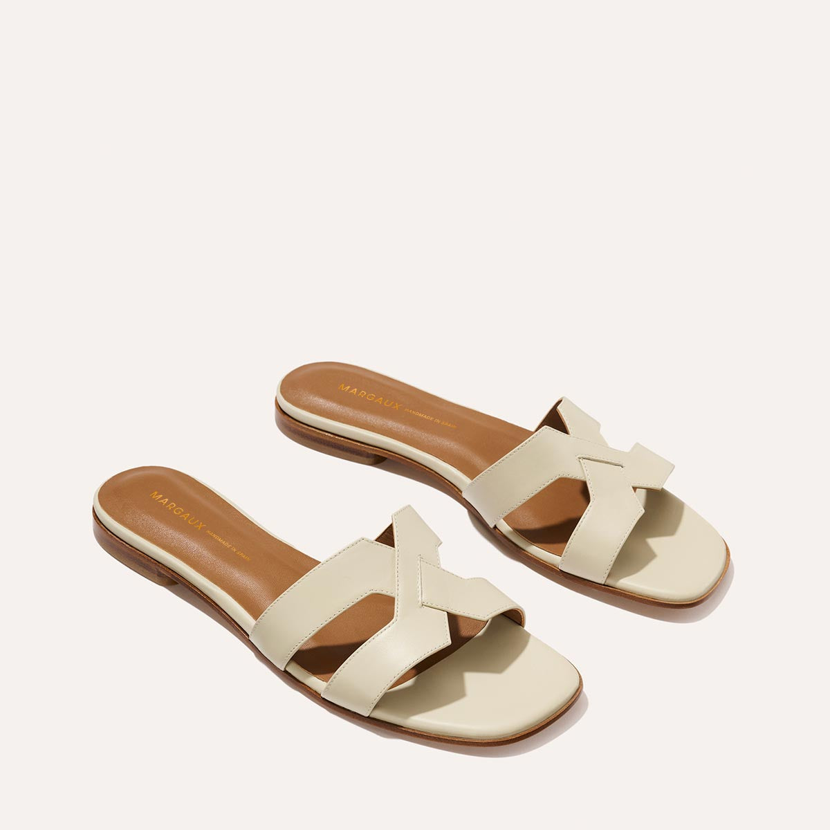 The MX Sandal in smooth Ecru leather, a slip-on sandal featuring embossed Italian leather with structured straps and a subtly square toe.