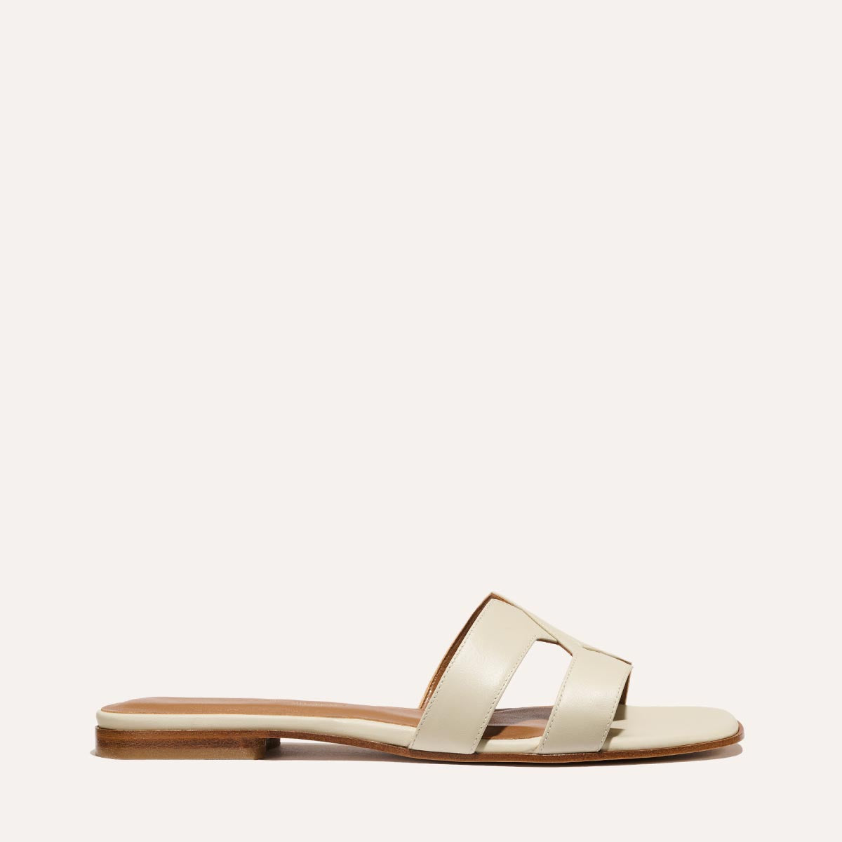 The MX Sandal in smooth Ecru leather, a slip-on sandal featuring embossed Italian leather with structured straps and a subtly square toe.