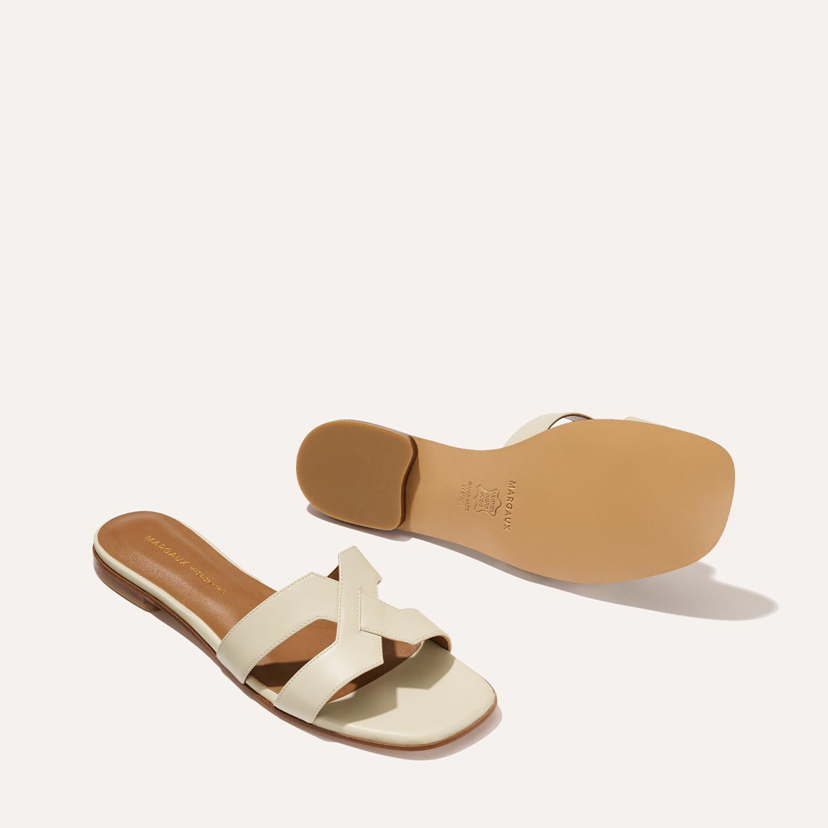 The MX Sandal in smooth Ecru leather, a slip-on sandal featuring embossed Italian leather with structured straps and a subtly square toe.