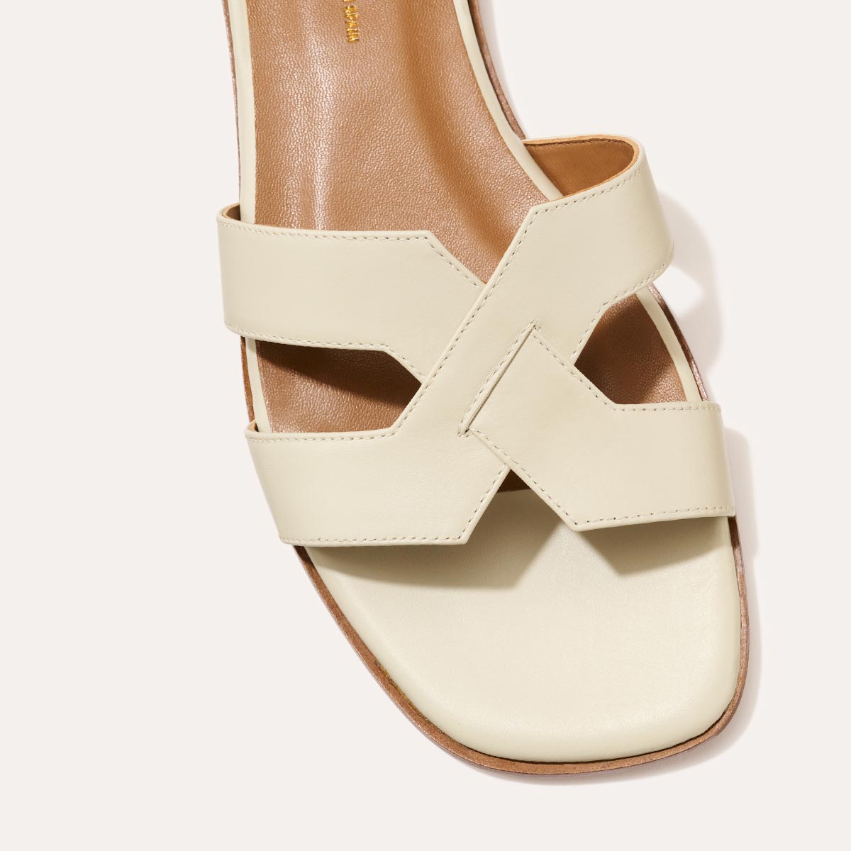 The MX Sandal in smooth Ecru leather, a slip-on sandal featuring embossed Italian leather with structured straps and a subtly square toe.